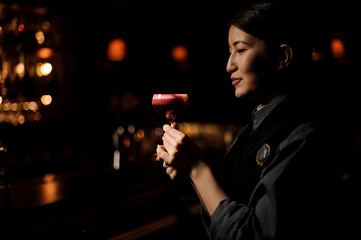 Portrait of bartender holding cocktail near bar counter