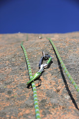 Seil mit Karabiner am Fels im Bohrhaken befestigt