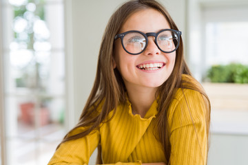 Beautiful young girl kid wearing glasses smiling looking side and staring away thinking.