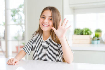 Beautiful young girl kid wearing stripes t-shirt showing and pointing up with fingers number five while smiling confident and happy.