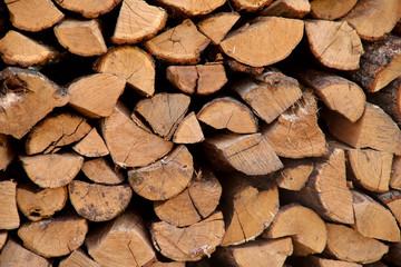 Background texture of stacked dry firewood. Side view, cropped shot, horizontal, close-up. The concept of nature.
