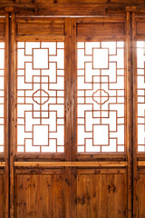 Closeup Chinese old wooden frame door with decorative pattern under the sunshine ,view from inside of building.