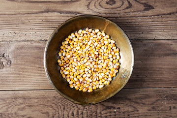 Maize in copper tray on wooden table
