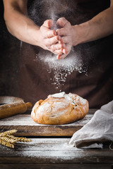 Baker cooking bread. Man slaps flour over the dough. Man's hands Making bread - obrazy, fototapety, plakaty