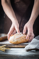 Baker cooking bread. Man slaps flour over the dough. Man's hands Making bread