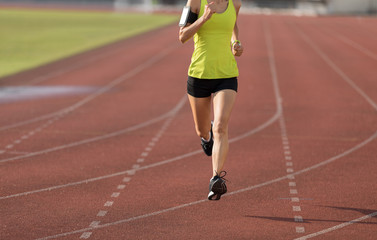Fitness sportswoman running on stadium race tracks