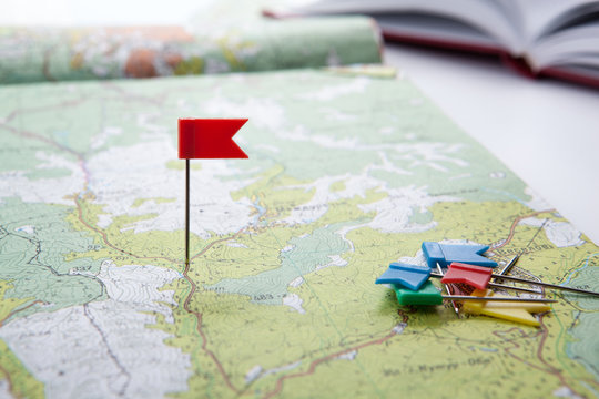topographic map with colored flag pushpins close up