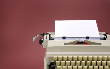 Typewriter from the 70s with blank paper for text on colored background.