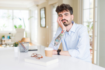 Young business man working thinking looking tired and bored with depression problems with crossed arms.