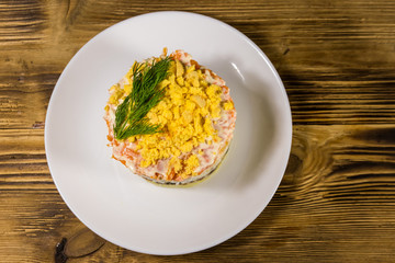 Traditional russian salad Mimosa on wooden table