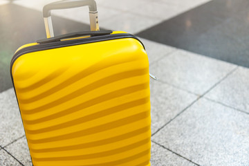 Girl is in the airport with bright and stylish cabin size suitcase as holiday concept