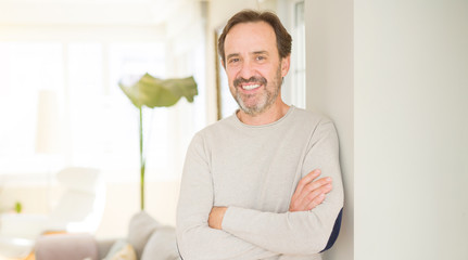 Handsome middle age man smiling looking at the camera at home