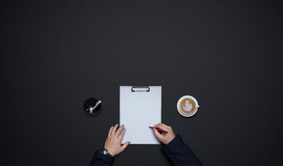 Businessman hands writing on white paper . Flat lay and top view with copy space on black...