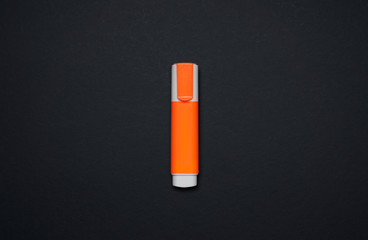 Orange highlighter pen isolated on black background . Flat lay and top view with copy space .
