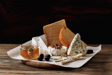 Different types of cheeses. slices of cheese brie or camembert with parmesan, cheddar ,blue cheese...