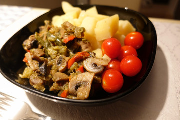 Freshly cooked boiled potatoes with mushrooms and cherry tomatoes. close-up. Vegetarian food. Dietary nutrition.