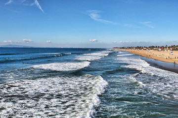 Long view of waves breaking over a beach coastline