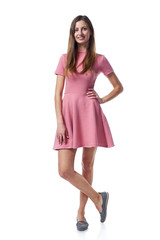 Fototapeta premium Full length of young woman in pink dress stadnign casually