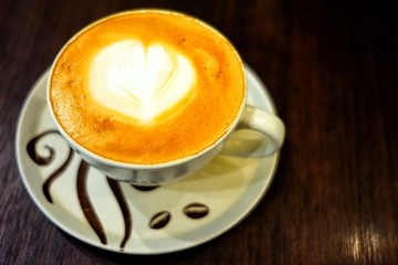 Cappuccino Cup on the Wooden Table with Light in Coffee Shop.