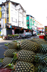 On the street are sold ripe fresh pineapples.