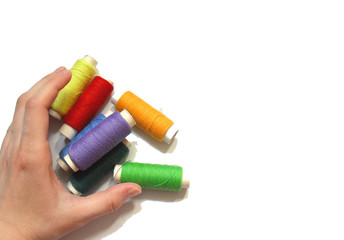 hand hold many threads of different bright colors