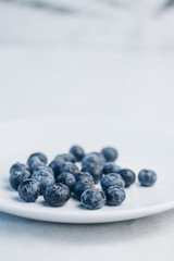 fresh blueberry berries on a white plate close-up. breakfast of wild berries. copy space