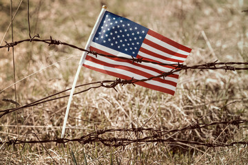 USA flag on old barbed wire fence