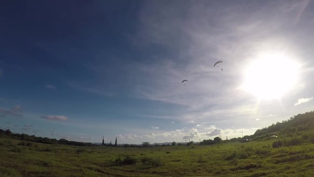 Soldiers arriving by parachute in an open field 2
