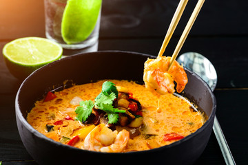 Spicy seafood noodles on black wood background.