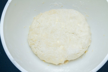 Raw mixed dough lies in a mixing bowl
