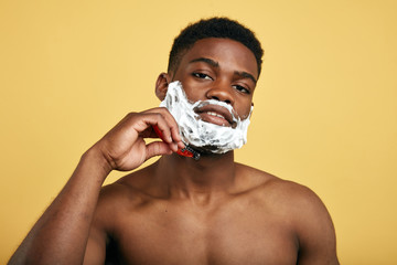 pleasant man using disposable razor in the bathroom. close up portrait.studio shot.