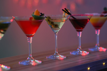 Different martini cocktails on table in bar, closeup