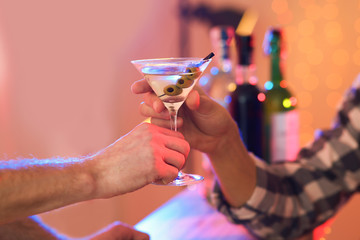 Young man taking martini cocktail from barman in pub, closeup