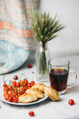 healthy light breakfast. sweet cherry with croissants on a plate. bouquet in a vase with spikelets of wheat. tea in a cup. proper nutrition for a slim figure. raw foods vegetarianism. diet