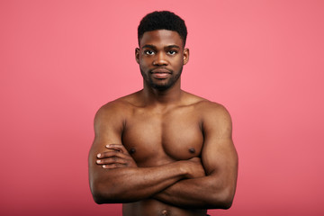 Fototapeta premium handsome awesome powerful confident man with crossed arms looking at the camera.fitness, beautiful body.confidence concept