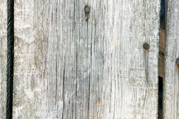 Texture of boards from the entrance door to the barn. On the boards you can see the trace of time through parallel cracks in the wood. Visible old rusty nails.