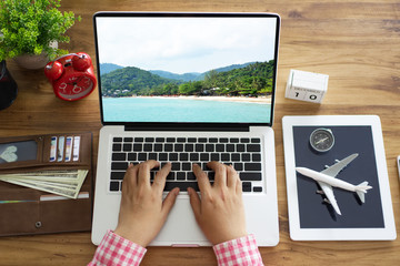 Top view businesswoman using computer searching attractions for travel on the vacation.