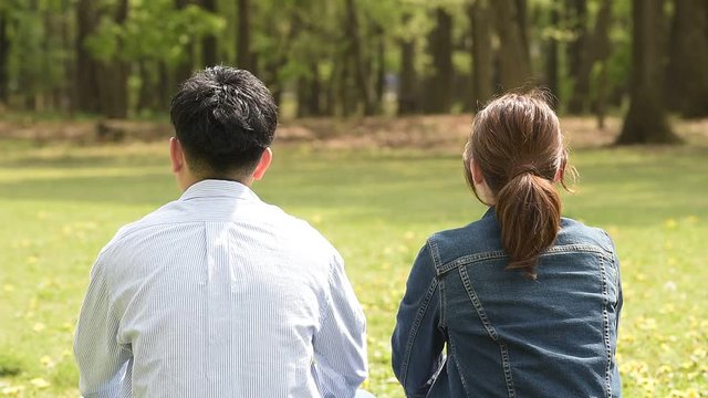 公園で寄り添う若いカップル