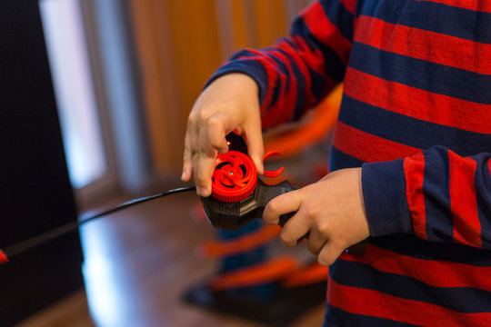 child playing with a wheelchair with a remote at home. radio controlled car toy for children. Boy with joystick plays with a toy car at home.