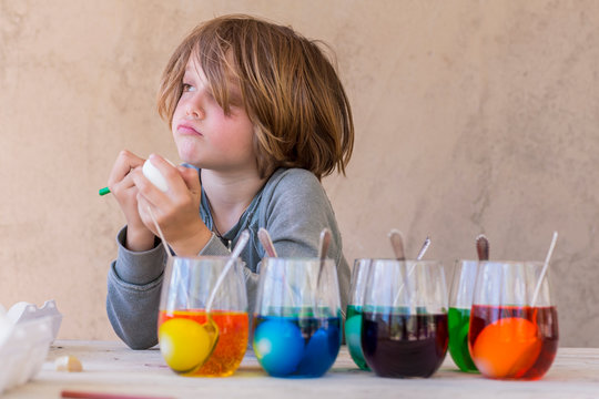 5 year old boy painting easter eggs