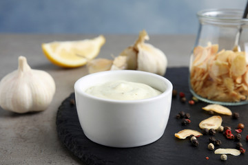 Composition with garlic sauce on grey table