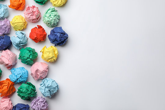 Colorful paper balls on white background, top view