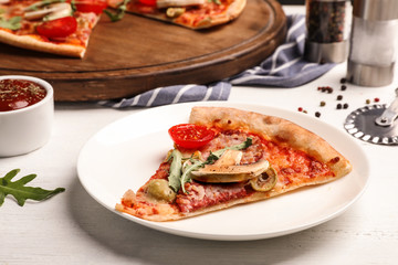 Plate with slice of delicious pizza baked in oven on table