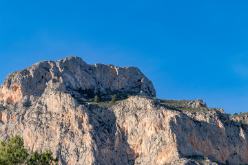 Detalle de montaña rocosa sobre cielo azul 