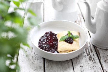 Pancakes stuffed with white cheese with dark fruit jam.