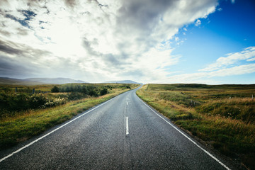 Fototapeta premium Trip or adventure: Abandoned, dramatic road in Scotland, cloudy sky.