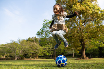 サッカーボールを飛び越える女の子