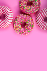 Pink donuts on a wooden background.