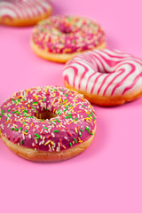 Pink donuts on a wooden background.