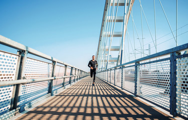 Jogging. Sportsman running over the bridge. Fitness, sport, lifestyle concept